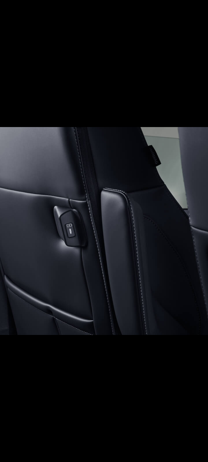 Nahaufnahme der Rückenlehne des Beifahrersitzes des Kia PV5 mit integriertem USB-C-Ladeanschluss
